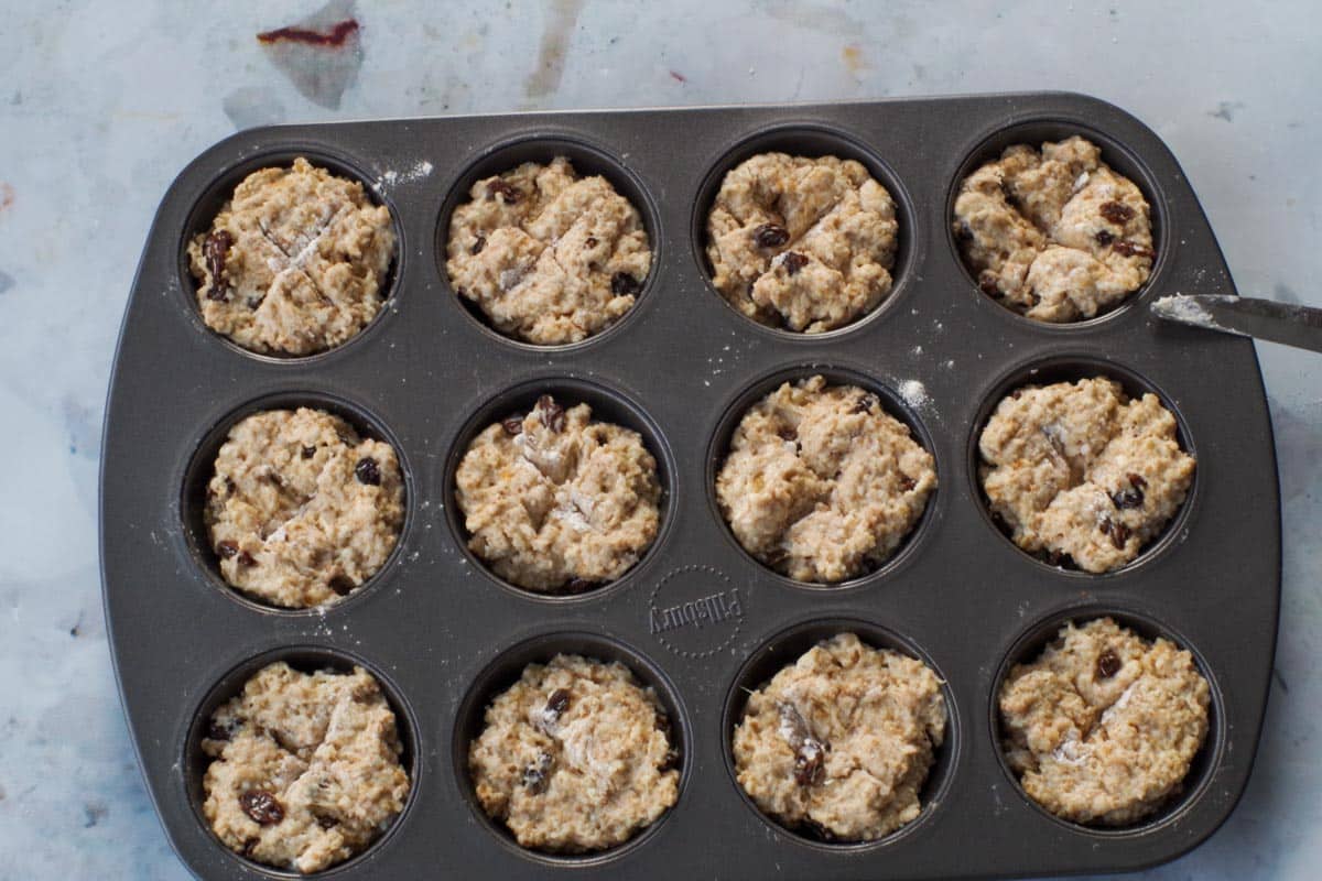 Raw muffins with and 'x' cut into them.