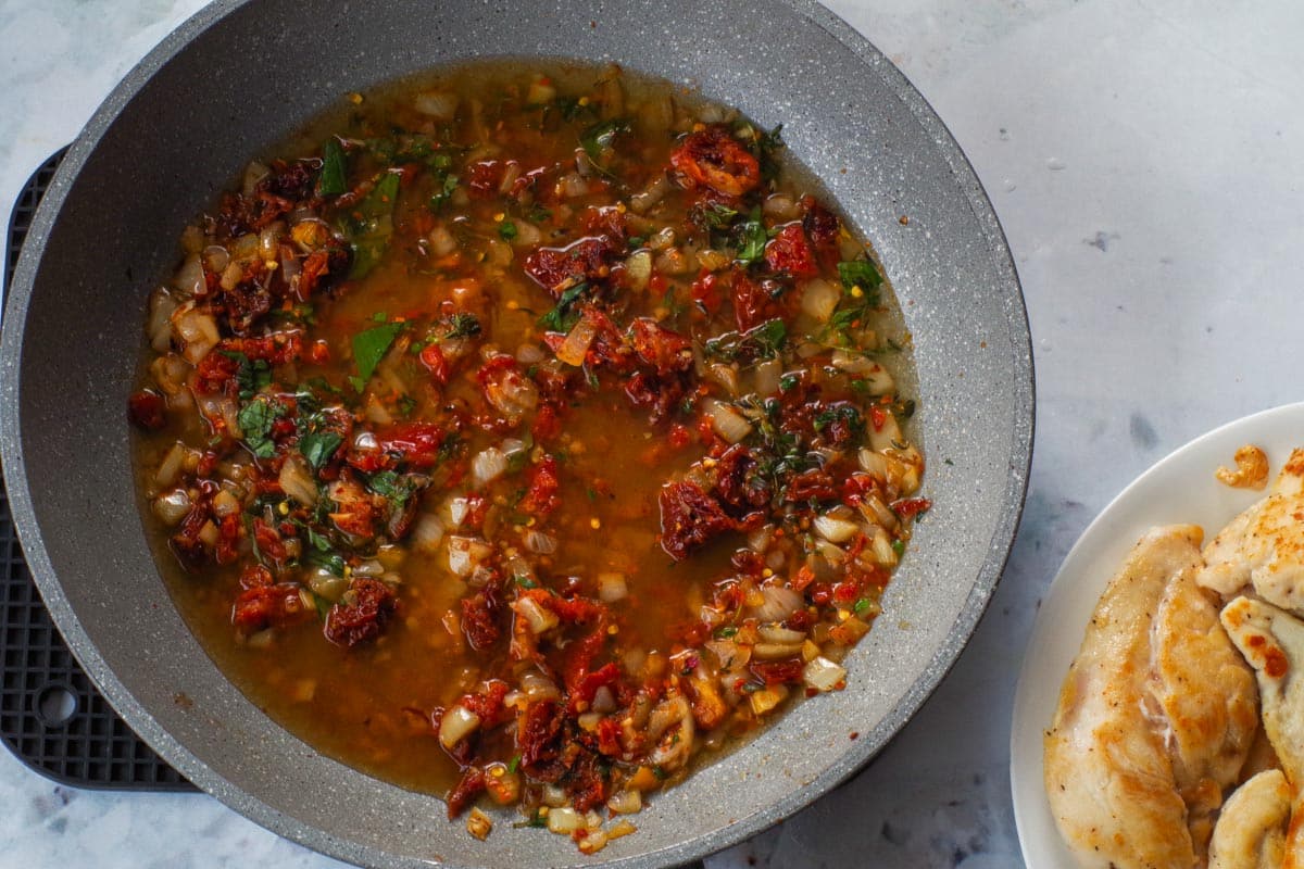 Herbs, broth, extract and red pepper flakes added to pan.