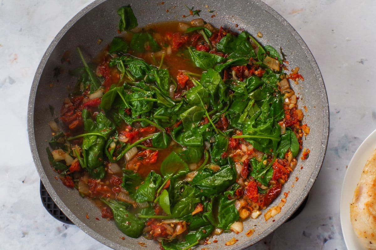 Baby spinach added to the pan and cooked until slightly wilted.