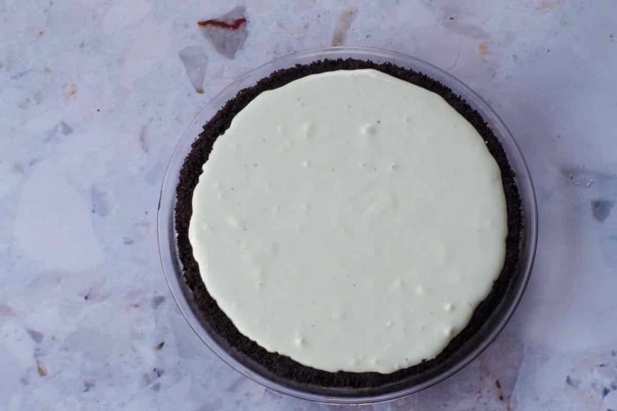 Whipped Cream and green cottage cheese/pudding mixture poured into pie shell.