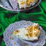 Healthy No Bake Pistachio Mousse Pie on a white plate with more pie in the background