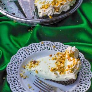 Healthy No Bake Pistachio Mousse Pie on a white plate with more pie in the background