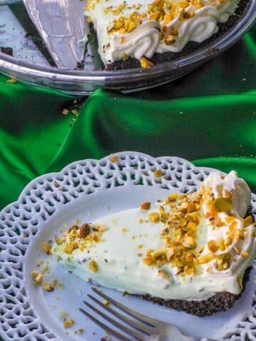Healthy No Bake Pistachio Mousse Pie on a white plate with more pie in the background