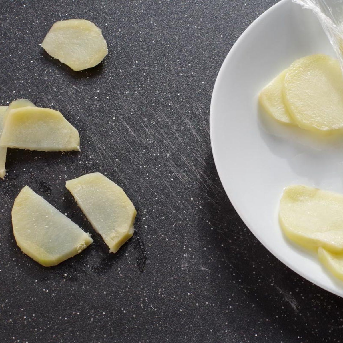 Cooked cactus potatoes on cutting board and on plate, covered in plastic wrap