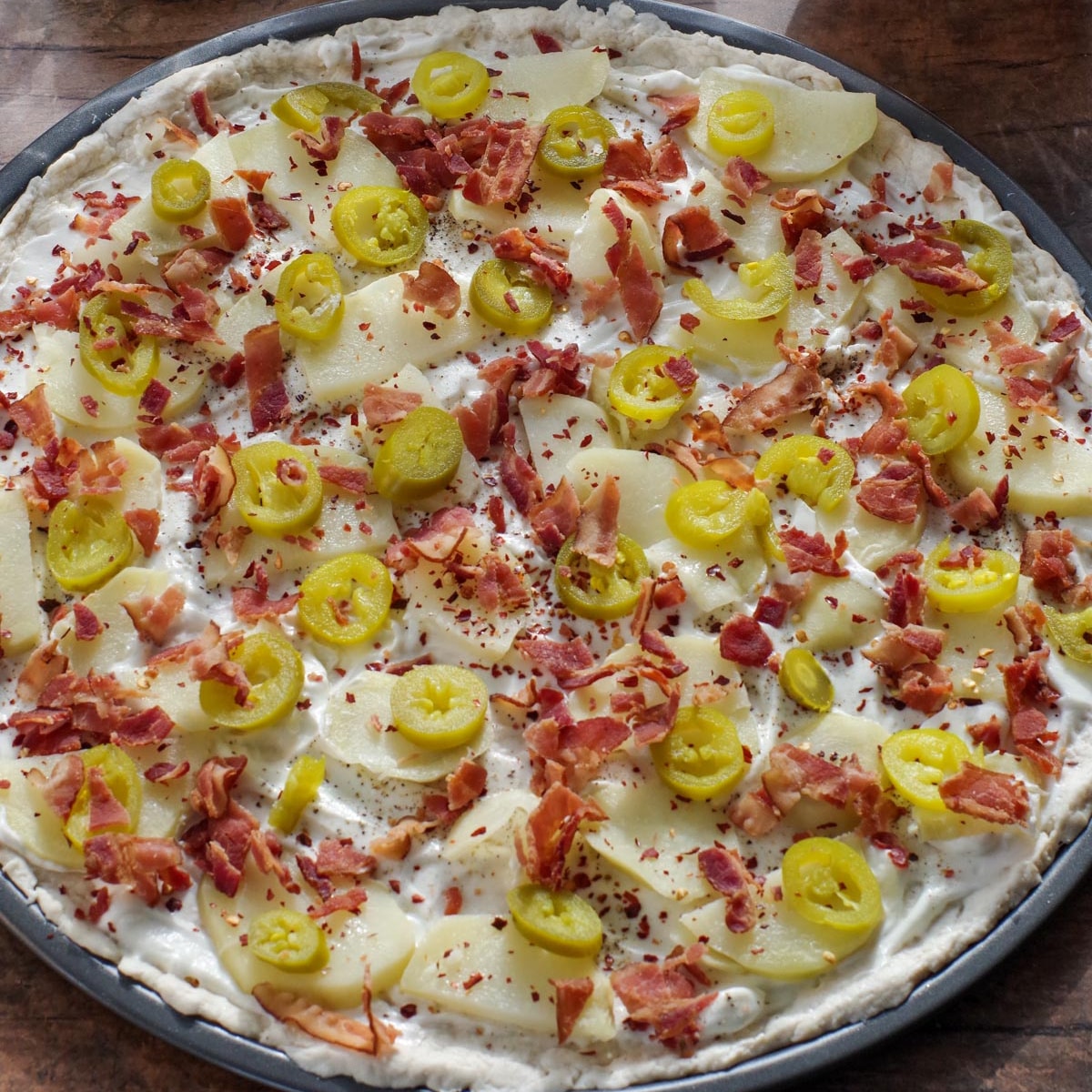 Spicy toppings and bacon added to perogy pizza.