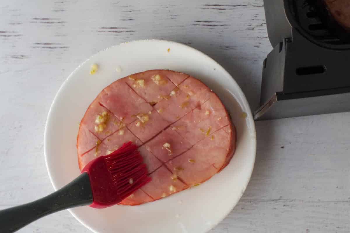 Ham Steak being brushed with marindae.