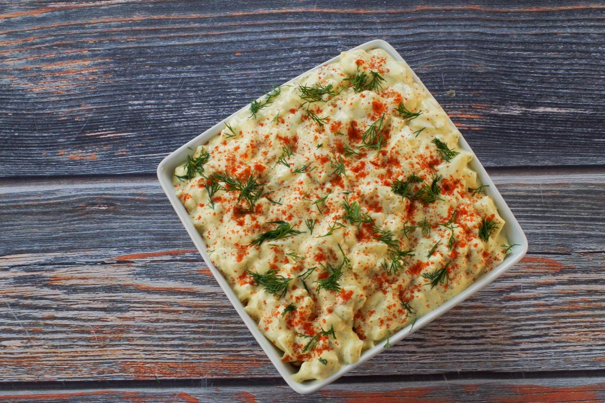 Dill Deviled Egg Dip in a white dish garnished with dill and paprika.