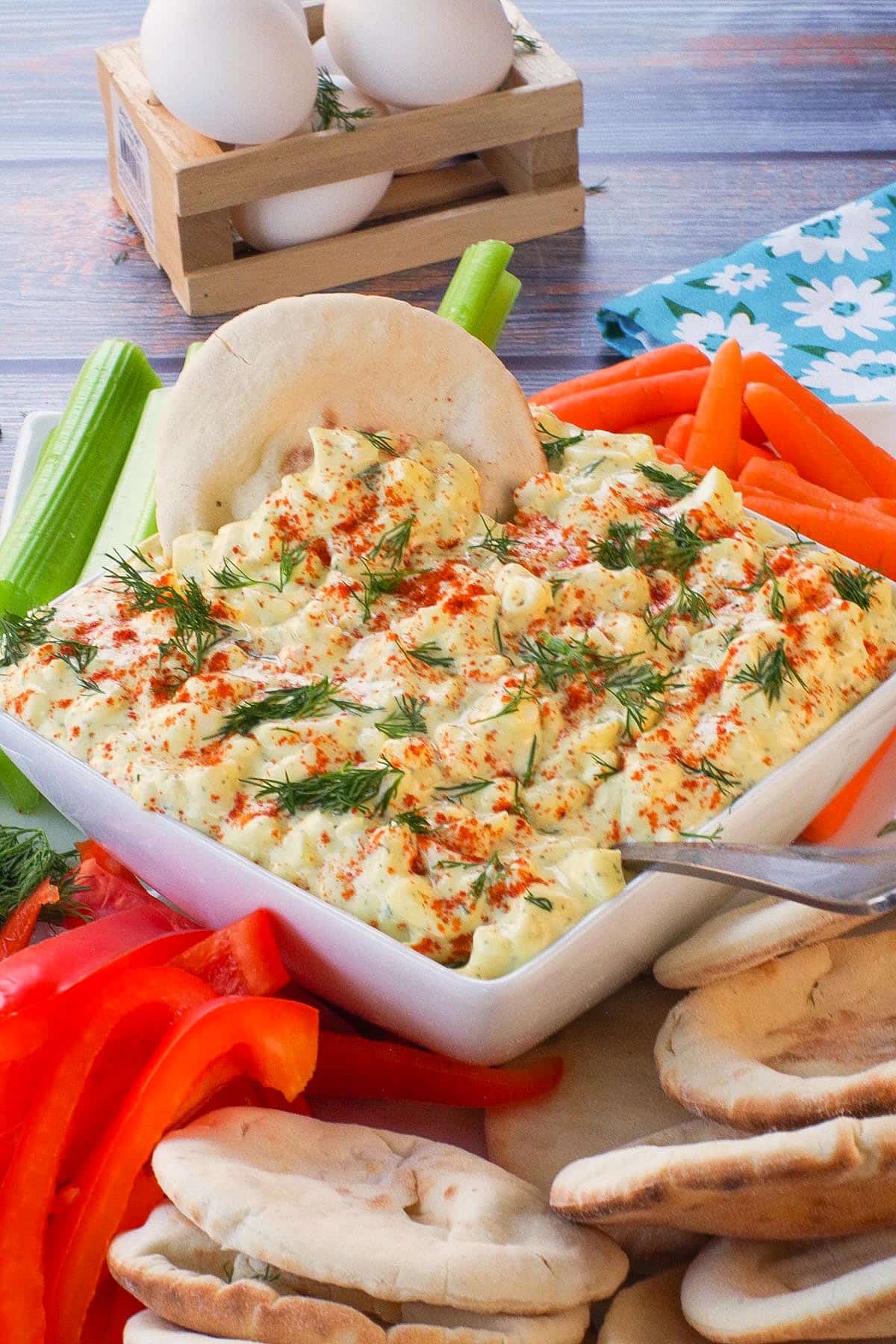Dill Deviled Egg Dip in the middle of a platter of vegetables and mini pita bread.