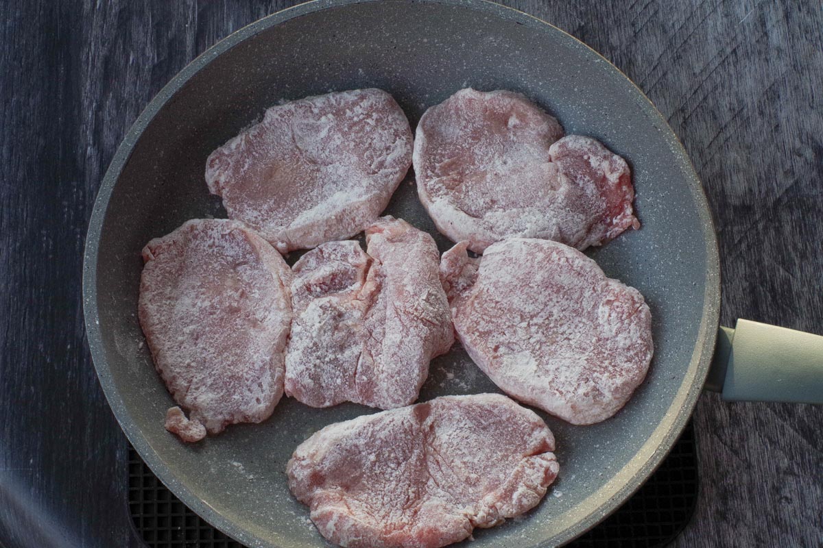 Floured pork in fryng pan.