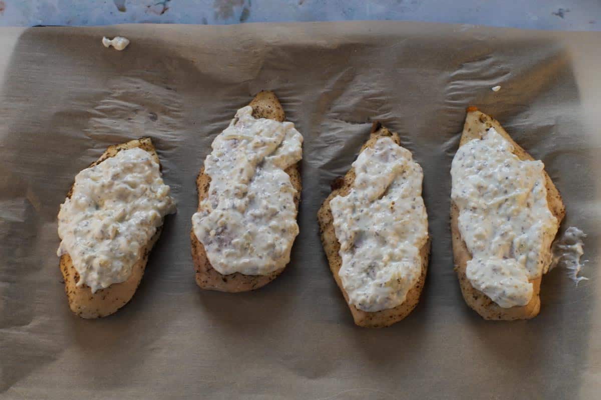 White sauce added to partially cooked chicken breasts.