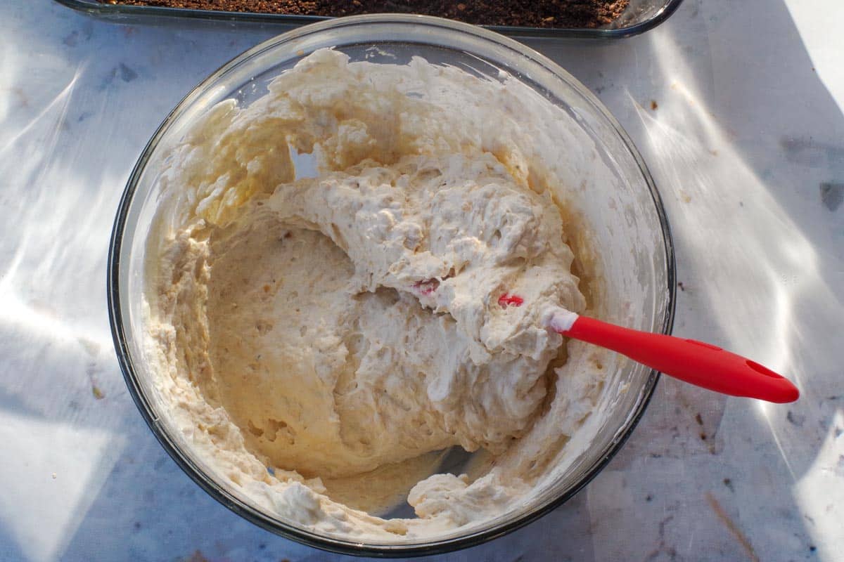 Cream cheese mixture and whipped cream mixtred together in glass bowl.