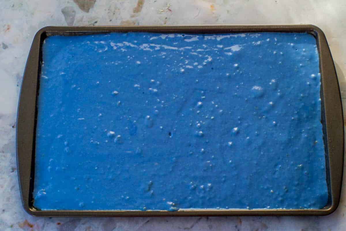 Blue Earth Day pancake batter poured onto a prepared sheet pan.