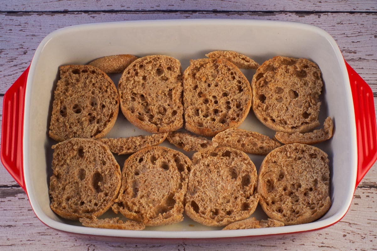 Englsh muffin halves and cut pieces in a casserole dish.