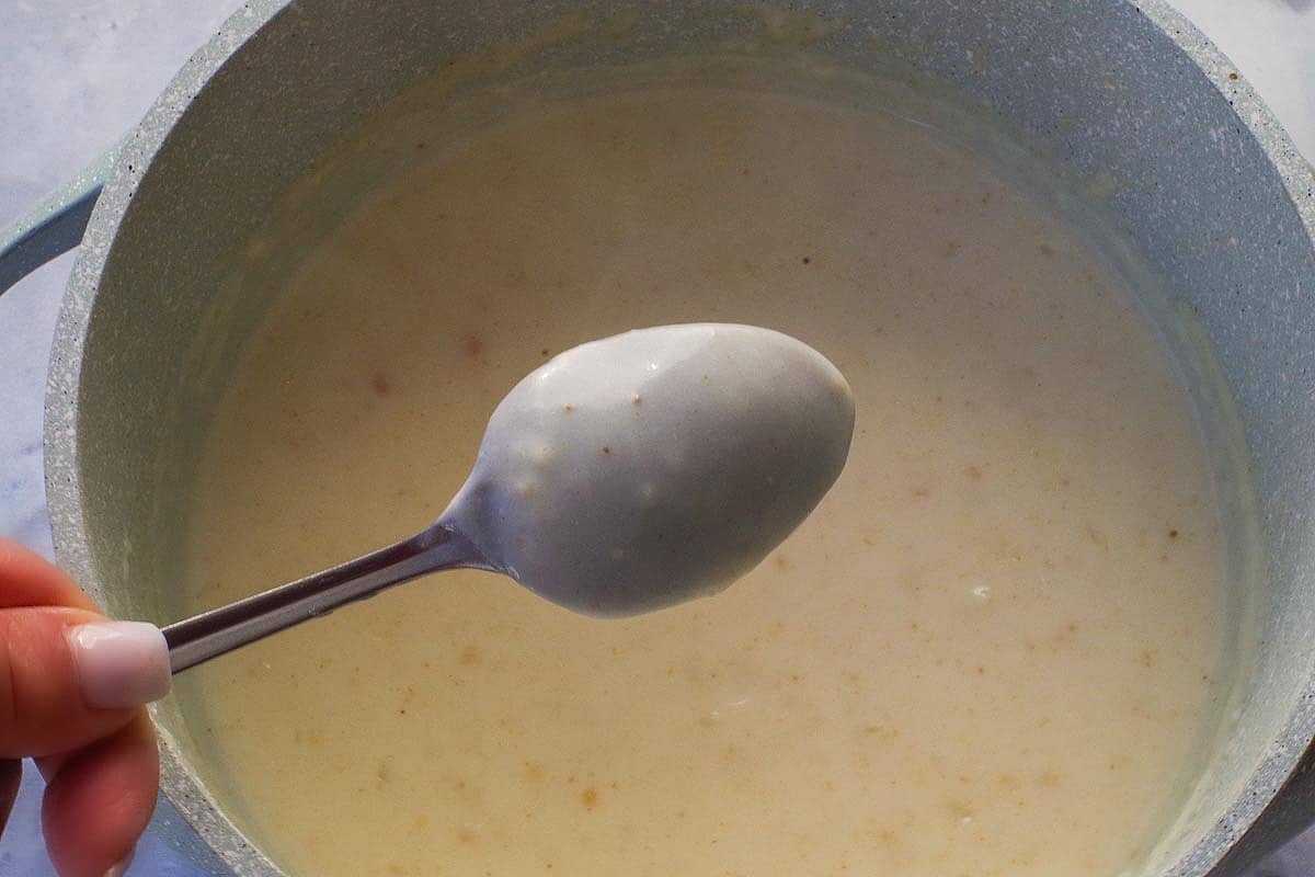 Back of spoon coated shows the sauce is thick enough.