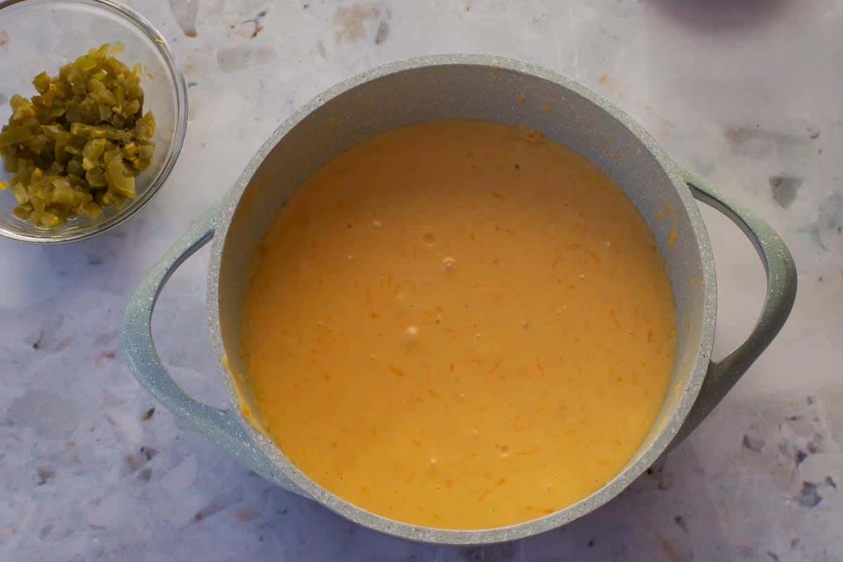 Cheese added to milk mixture for New Mexican Chile Con Queso DIp.