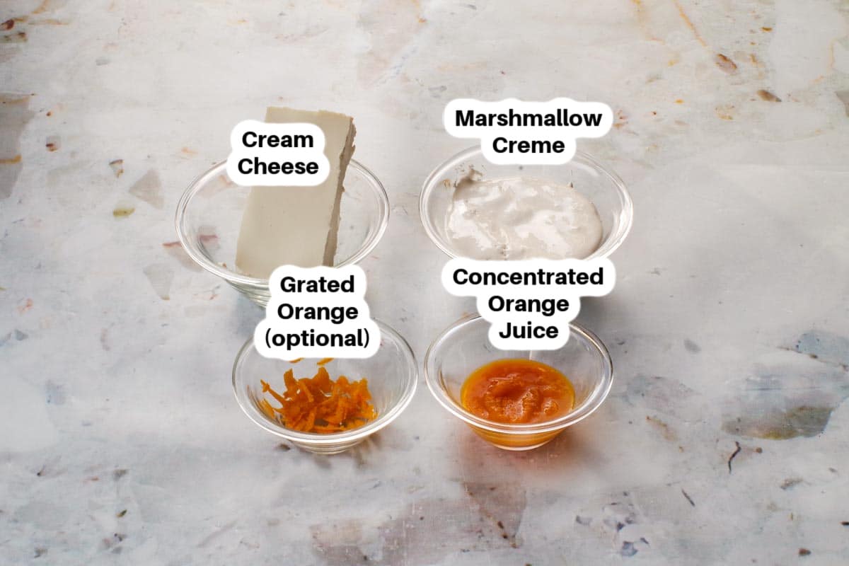 Ingredients needed for Orange Creamsicle Dip in glass bowls, labelled.