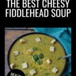 A bowl of The Best Cheesy Fiddlehead Soup with a blue napkin beside it.