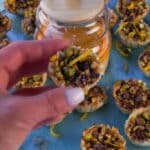 Hand holding up Chocolate Baklava Cup with honey and more Baklava Cups in the background.