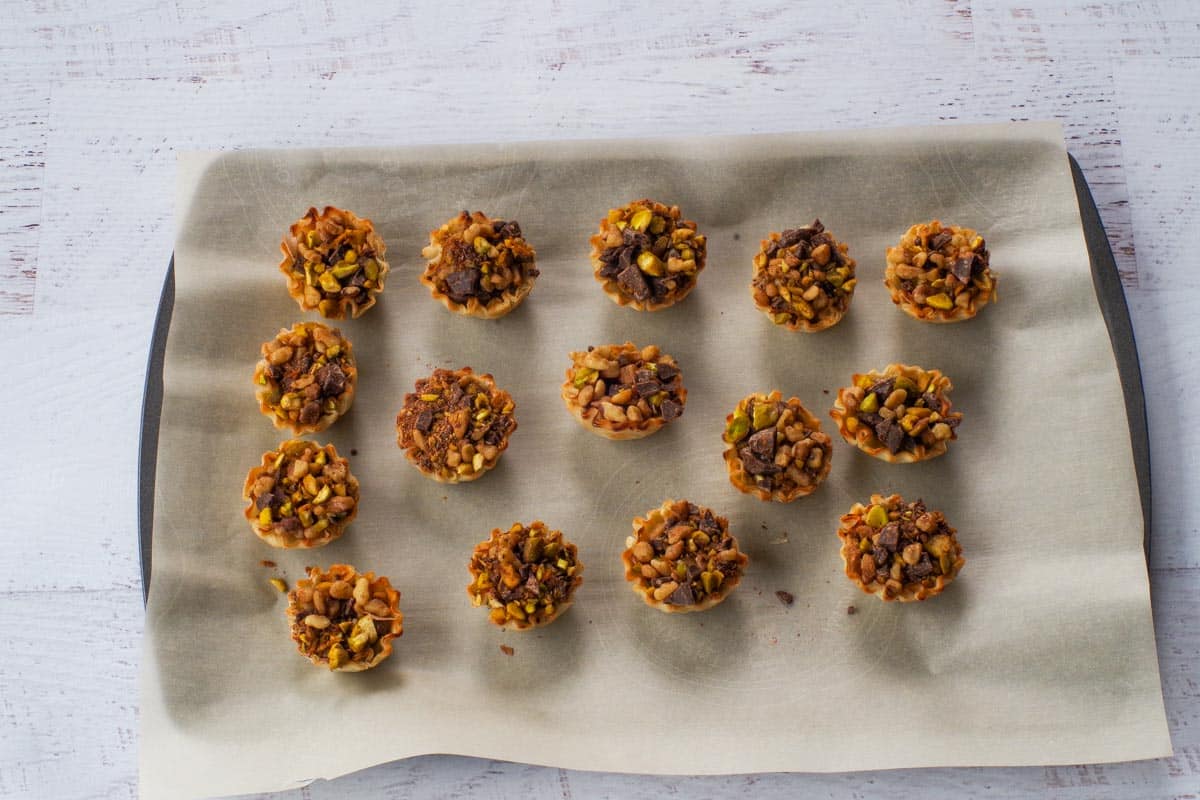Filled phyllo shells on a parchment covered baking sheet.