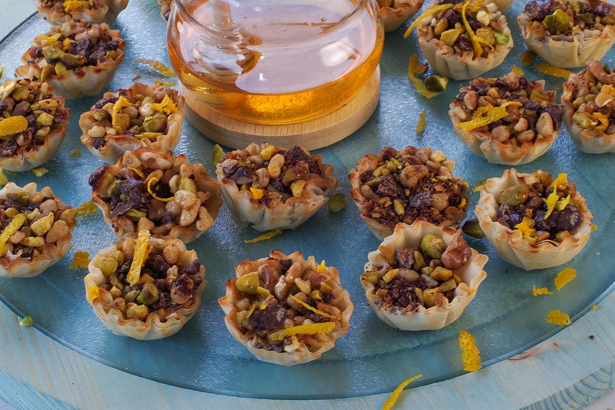 Baklava Phyllo Bites on a blue round wood and glass platter.