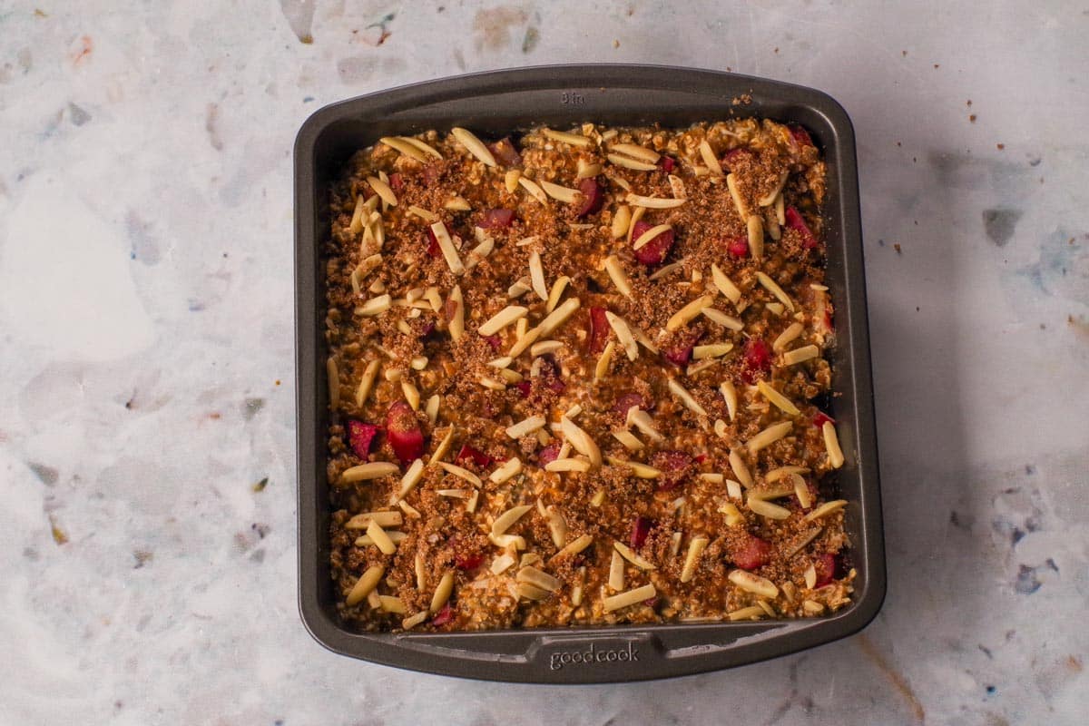 Rhubarb baked oatmeal batter with almonds and topping sprinkled on top.
