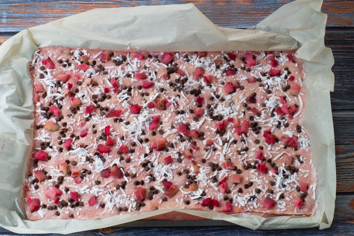 Frozen rhubarb yogurt bark on a parchment lined baking sheet.