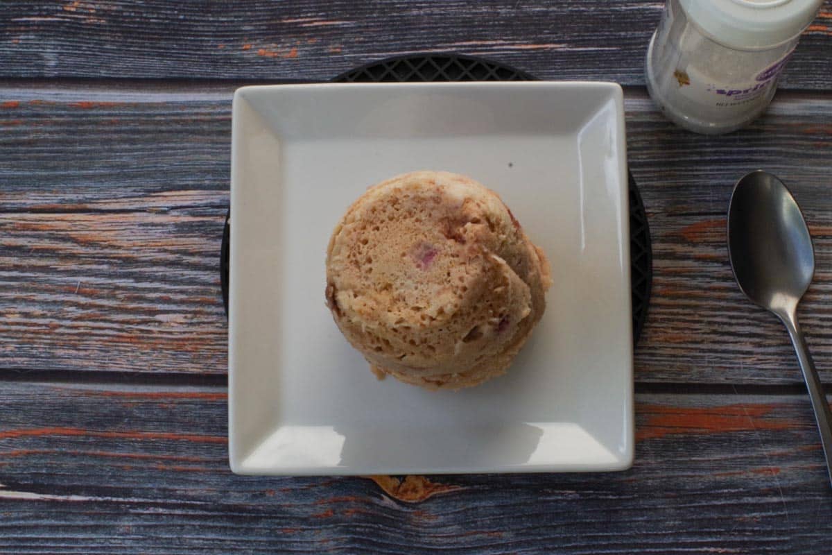 Rhubarb Mug Muffin turned upside down on a white square plate.
