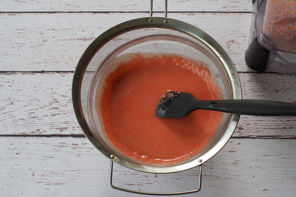 Rhubarb Vinaigrette being strained through a seive