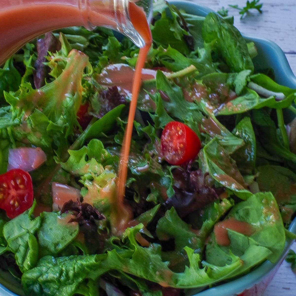 Rhubarb Vinaigrette being poured onto a salad.
