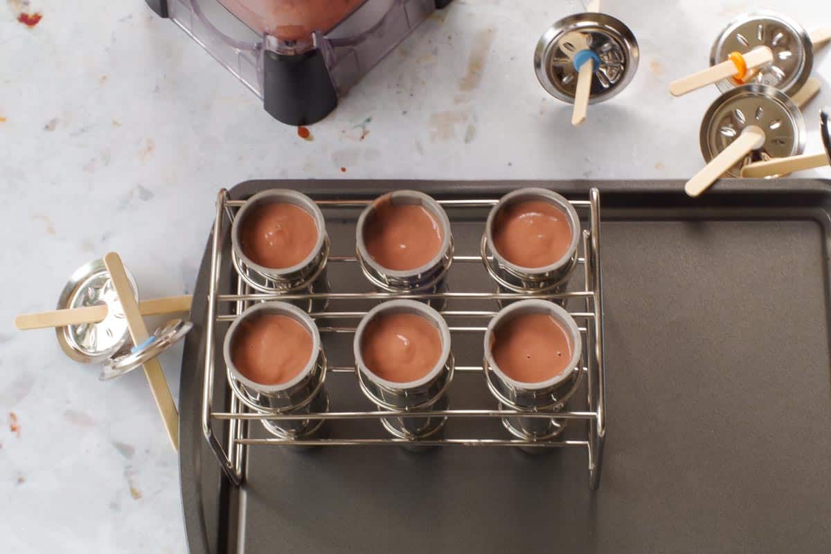Chocolate Rhubarb Popscicle mixture poured into stainless steel popsicle molds.