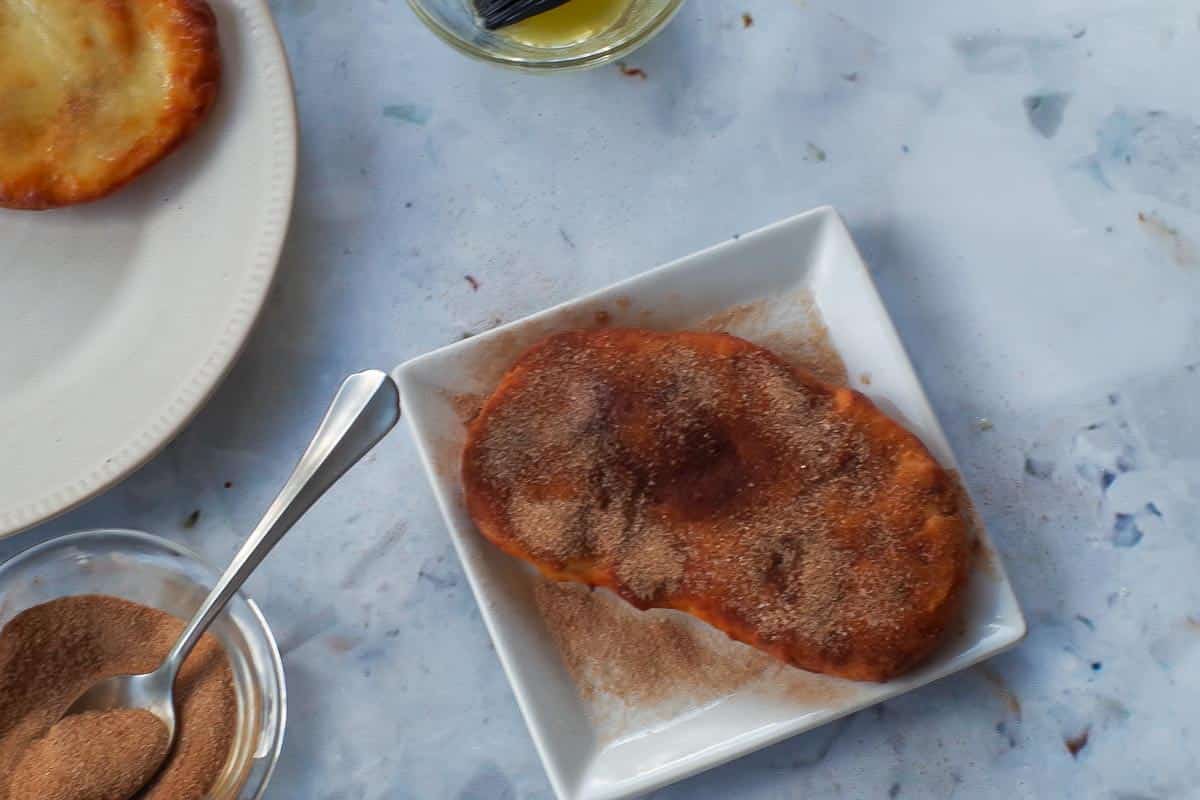 Cinnamon Sugar mixture sprinkled on Beaver Tail on a white plate.