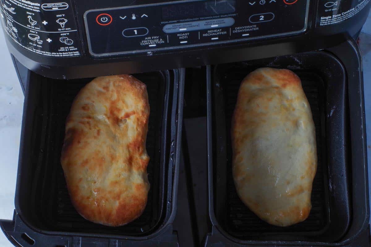 1st side of air fryer beaver tails cooked to a light golden brown in air fryer drawers.