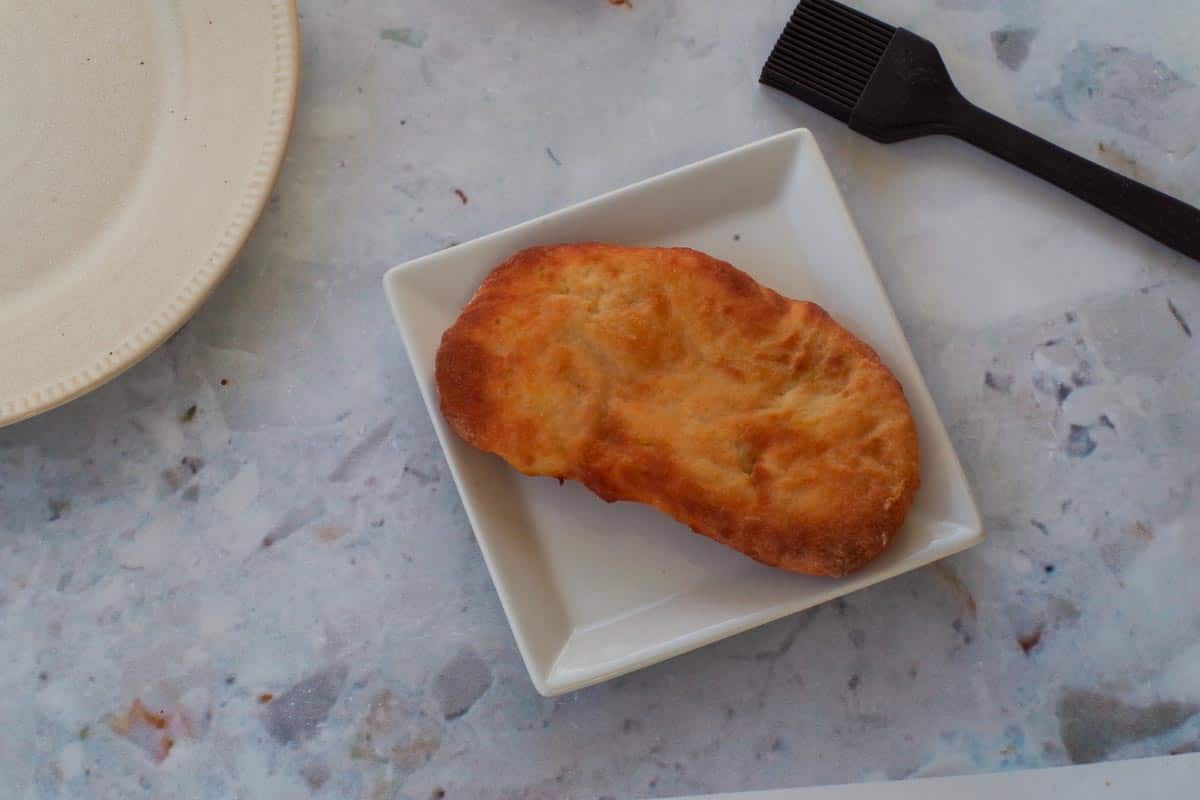 Cooked Air Fryer Healthy Beaver Tail on a white plate with a pastry brush beside it.