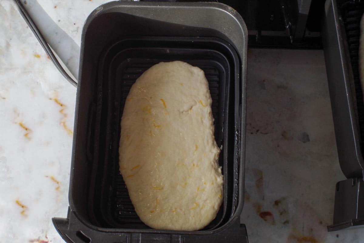 Beaver Tail in drawer of air fryer, sprayed with oil.
