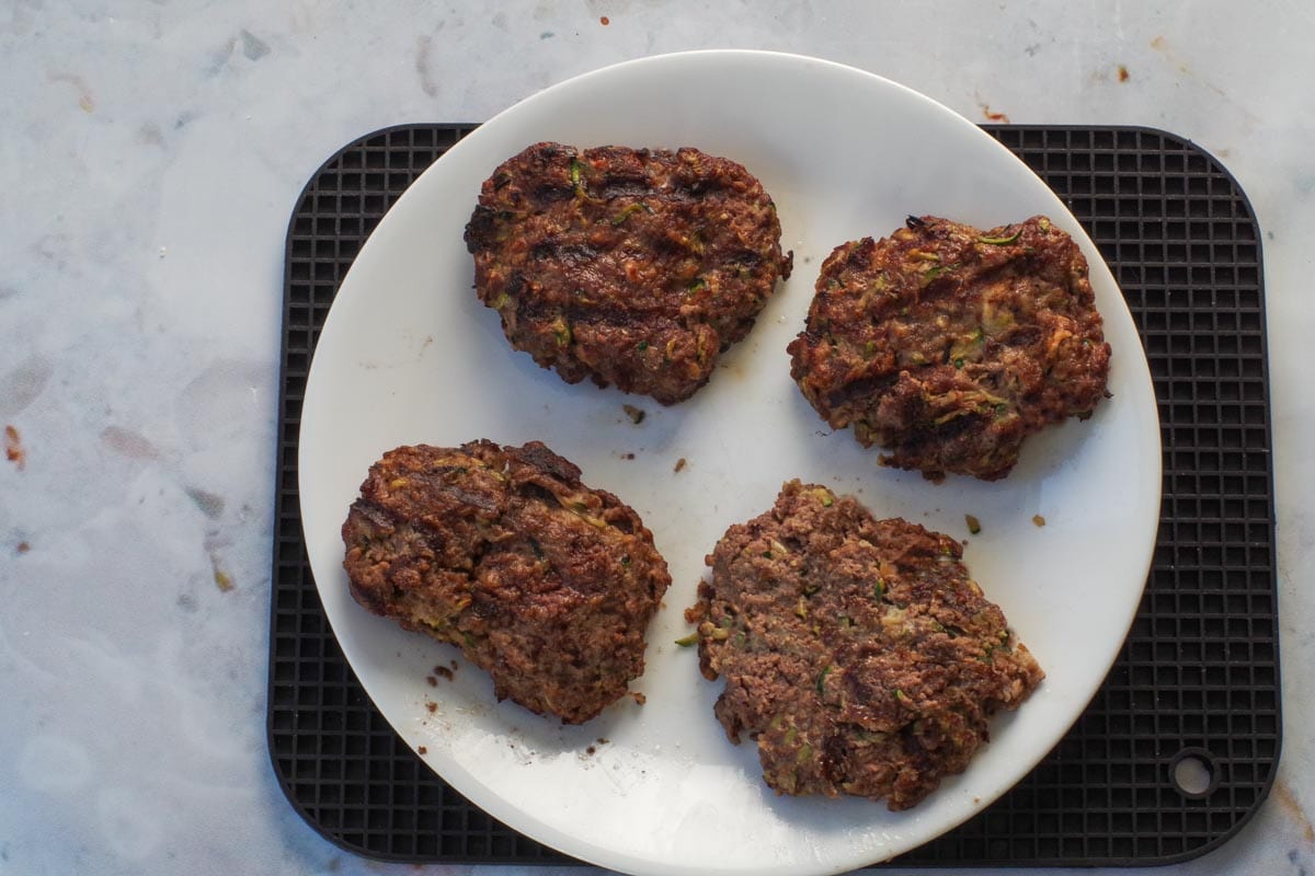 4 Grilled Salisbury Steaks on a white plate.