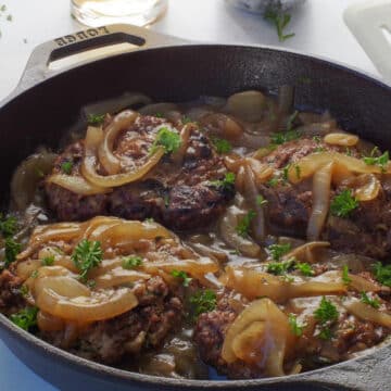 Grilled healthy Salisbury Steak with Beer and Onion Gravy in a cast iron pan
