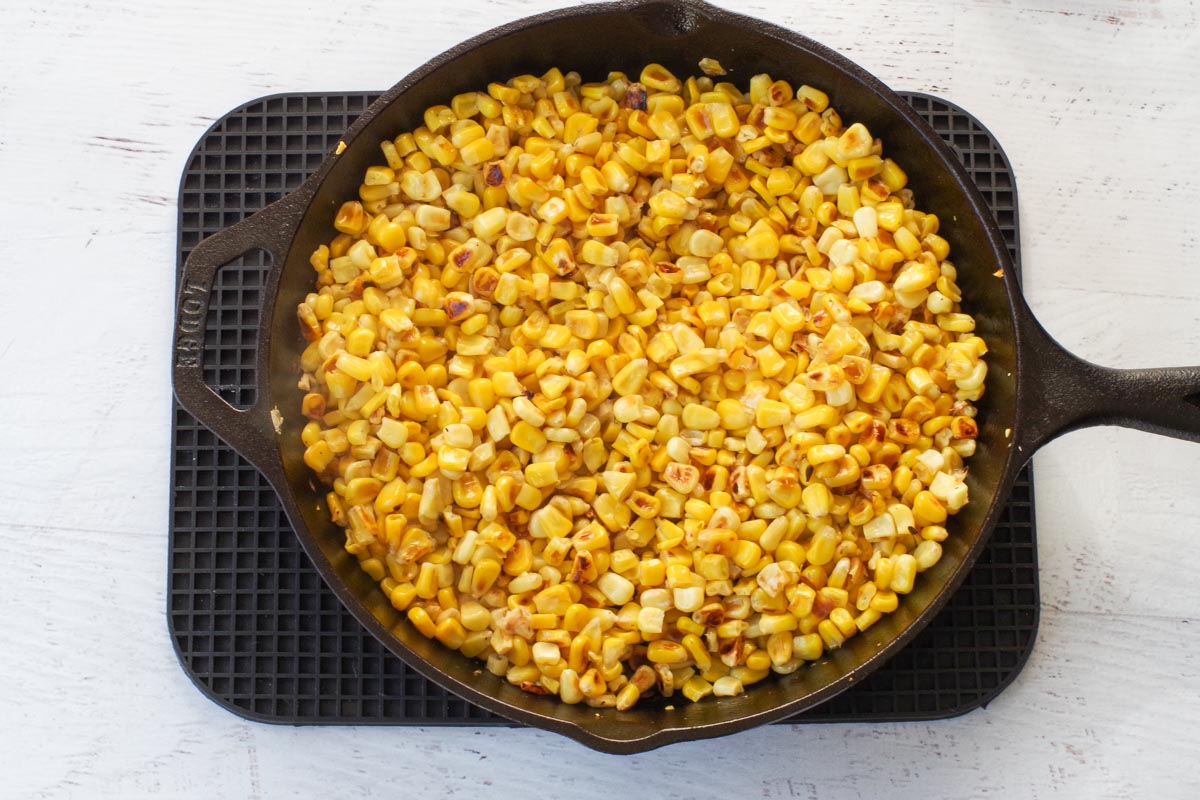 Corn in skillet with some browned pieces.