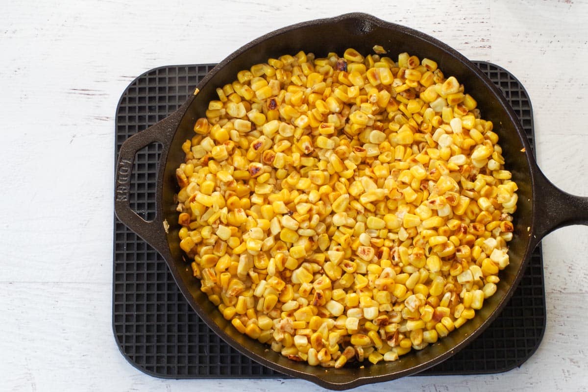 Corn with more browned pieces in cast iron skillet.