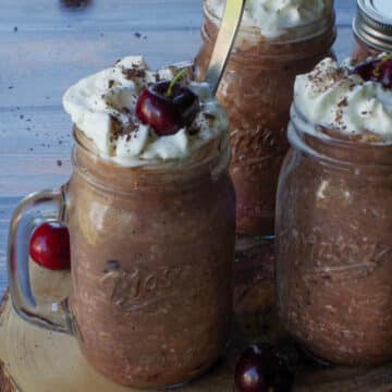 4 jars of Black Forest Overnight Oats, on a piece of round wood.