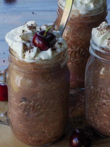 4 jars of Black Forest Overnight Oats, on a piece of round wood.