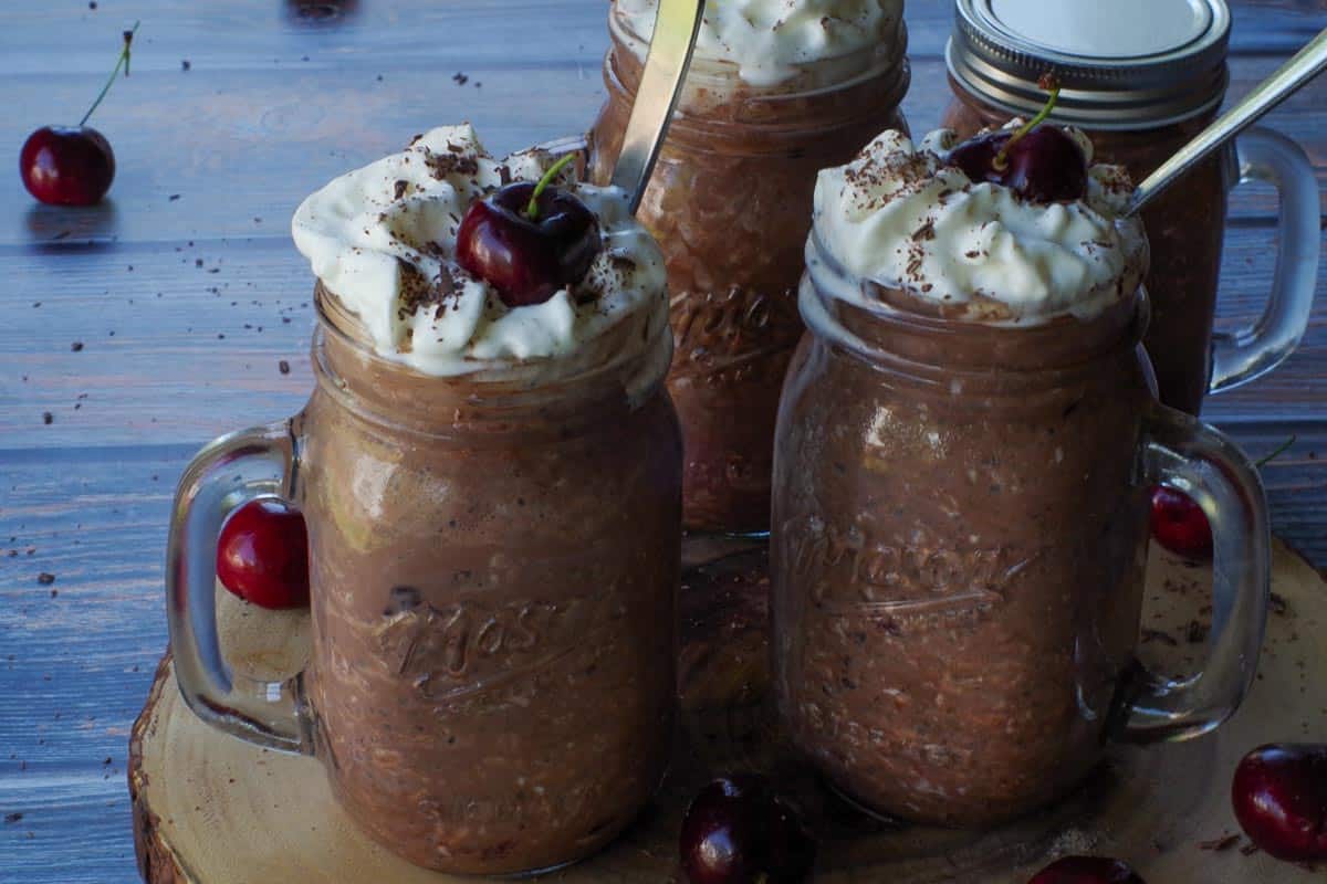 4 jars of Black Forest Overnight Oats, on a piece of round wood.
