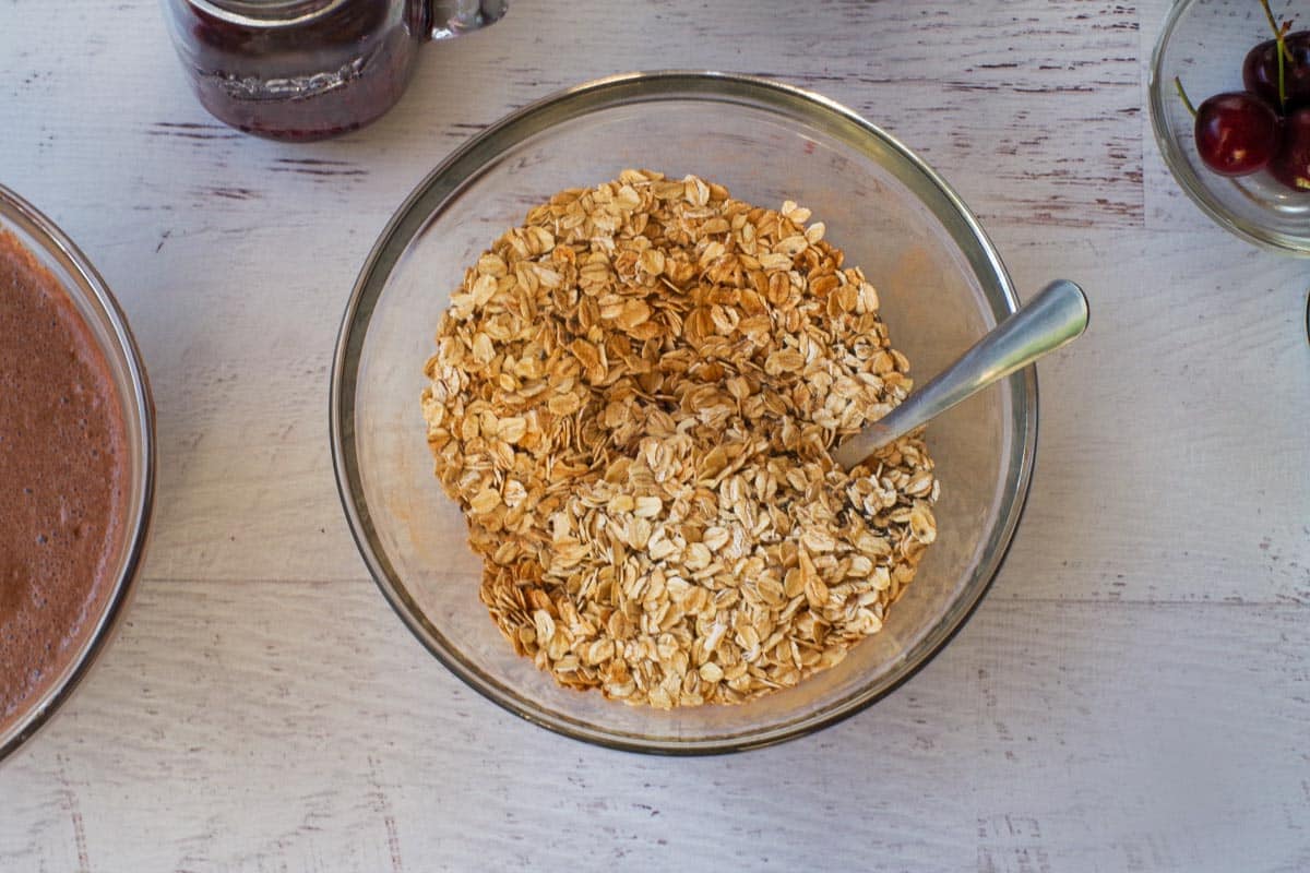 Rolled oats, chia seeds and cinnamon mixed together in a glass bowl.