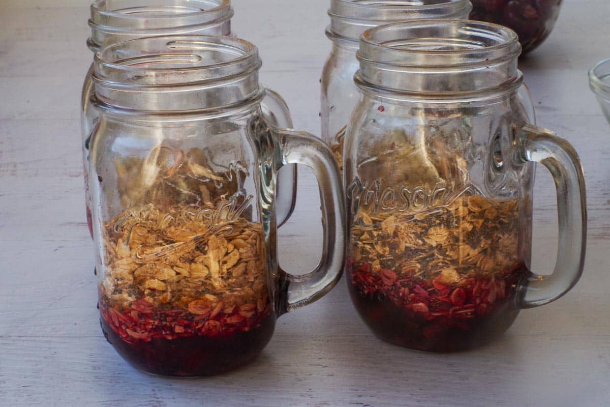 Oat mixture divided by 4 and added on top of cherry mixture in jars.