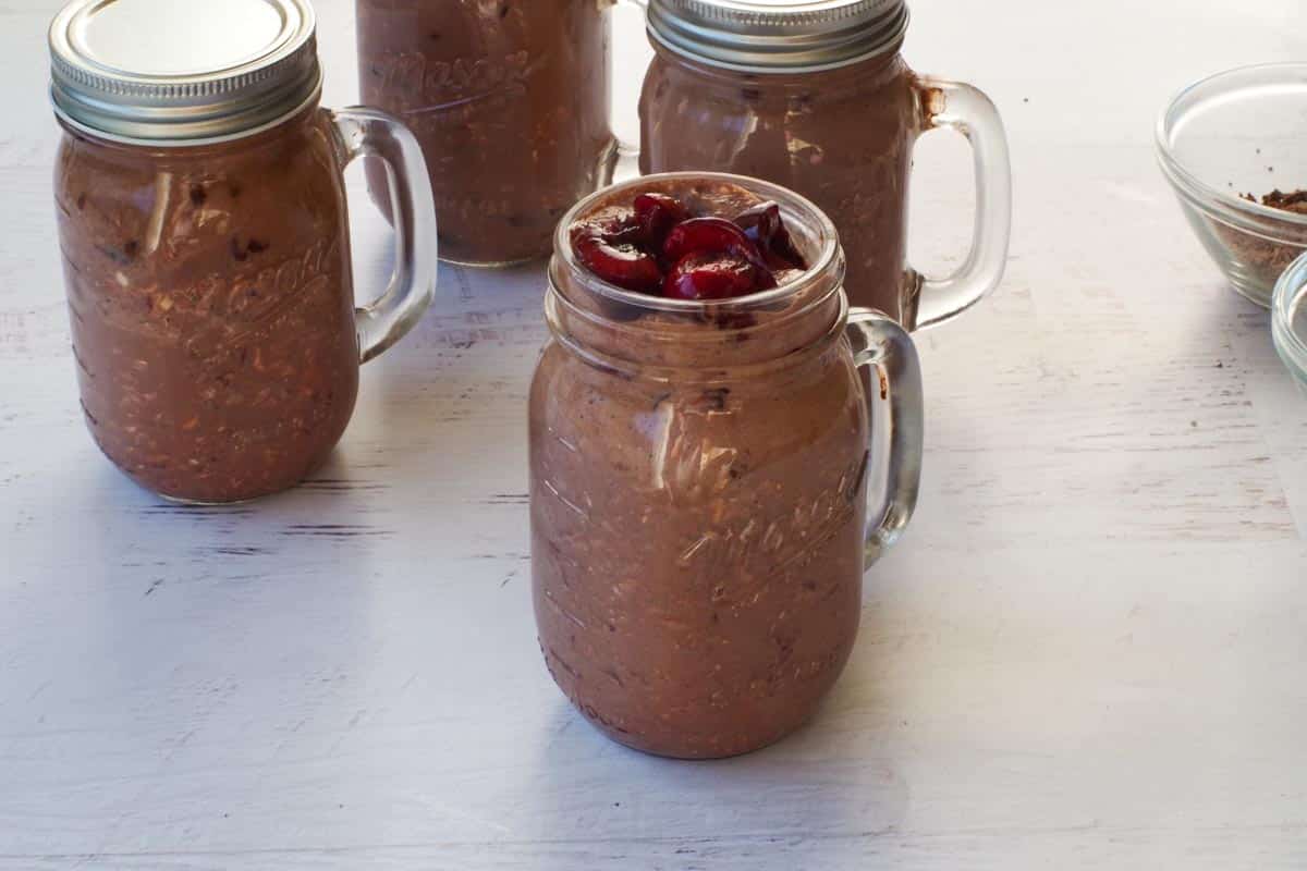 Halved Cherries added to top of jars, dividing evenly by all 4 jars.