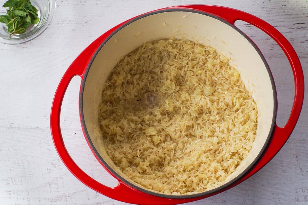 Dry rice added to onions in Dutch oven.