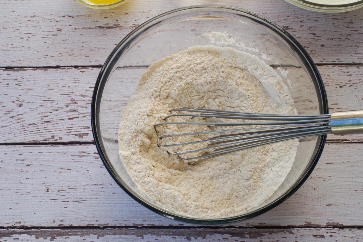 Dry ingredients for oven baked old fashioned pancakes in a bowl with a metal whisk.
