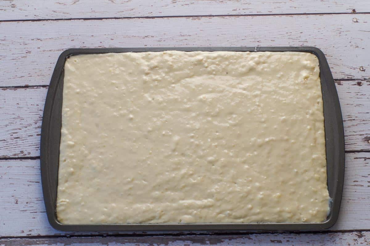 Batter for old fashioned oven baked pancakes poured onto 9x13 sheet pan.