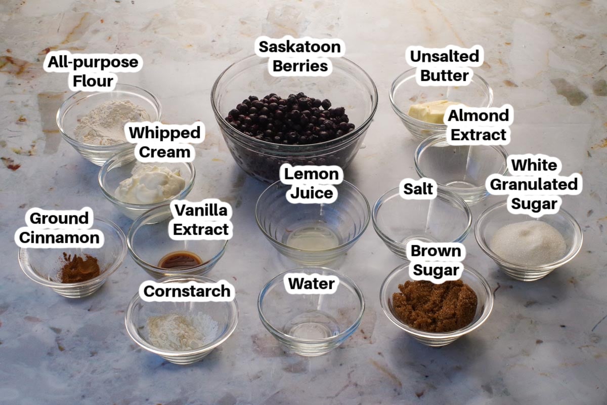 Ingredients in Old Fashioned Saskatoon Berry Crumble in glass bowls, labelled.