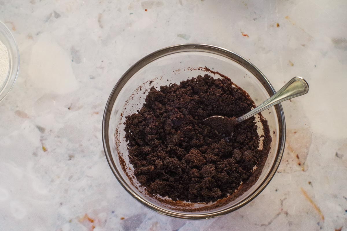 Butter and chocolate baking crumbs mixed together in a glass bowl.