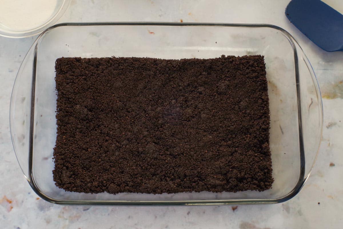 Chocolate baking crumbs mixture pressed into a 9x13 pan.